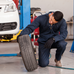 Repair technician changing old tire in service bay